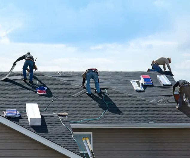 Roofers working on a shingle roof